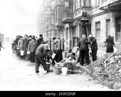 Berliner si allineano per l'acqua : Berliner si trova di fronte ad una pompa d'acqua su una strada, in attesa di riempire le loro vele negli ultimi giorni prima della caduta della capitale tedesca. Ci sono state linee a queste pompe giorno e notte durante gli ultimi giorni della città, poiché l'unica fonte d'acqua disponibile era il fallo, zio un'acqua da questi pozzi. Luglio 31, 1945. (Foto di stampa associata). Foto Stock