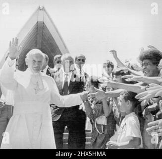 Papa Giovanni Paolo II ondeggia in attesa di folla dopo aver lasciato il teatro lirico di Sydney questa mattina. Il papa ha fatto una visita di un'ora e ha visto una delle attrazioni più popolari di Sydney durante la sua visita di due giorni a Sydney. Novembre 26, 1940. (Foto di AP Wirephoto). Foto Stock