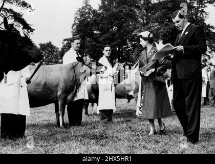 Royal Visitors at the Royal Show -- H.M. la Regina ha visto girare le linee di bestiame durante la sua visita al Royal Show a Nottingham ieri, con H.R.H. il duca di Edimburgo in seguito in background. Per questa occasione sua Maestà indossava un cappotto di seta blu reale, sopra un abito floreale, con un cappello che si fa abbracciare la testa di fiori rosa. H.M. la Regina e H.R.H. il Duca di Edimburgo ha fatto una visita al Royal Agricultural Show 1955, ora in corso al Wollston Park di Nottingham, mercoledì 6th luglio., il secondo giorno dello spettacolo. Luglio 7, 1955. (Foto di Fox Photos). Foto Stock