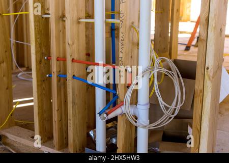 Un nuovo edificio in costruzione con impianto di trattamento delle acque reflue in PVC rosso caldo e blu freddo Foto Stock