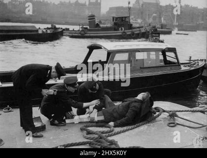 La polizia del Tamigi una pattuglia di polizia del fiume presta attenzione medica ad un bargeo ferito sul Tamigi. La parte più antica della Metropolitan Police Force di Londra, la Thames River Police, fu formata nel 1798. Nel 1839, dieci anni dopo che Sir Robert Peel aveva formato la sua forza di polizia, i due si unì per diventare la polizia metropolitana come la conosciamo oggi. La stazione di polizia sul fiume a Wapping è costruita sul sito della più antica corte di Londra, la "Corte di polizia del Tamigi". Anche se mantengono un punto di vista acuto per i illeciti, la polizia di fiume è più spesso impiegata nel rendere il primo aiuto a. Foto Stock