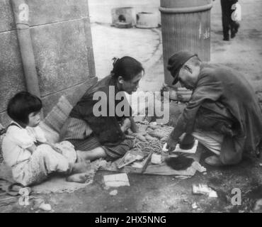 Yank bombe messo Tokyo Merchant sul marciapiede -- giapponese Merchant (a destra) continua il commercio sul marciapiede dopo che i bombardamenti americani hanno distrutto il suo deposito. Settembre 11, 1945. (Foto di AP Wirephoto). Foto Stock