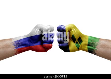 Due mani si pugno l'una all'altra su sfondo bianco. Bandiere di paese dipinte pugni, conflitto concetto di crisi tra la russia e saint vincent e il gren Foto Stock