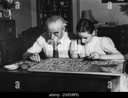 Così serio -- il sig. George Robey, 83 domani, è il primo ministro di Mirth. Ma il suo umore non potrebbe essere più serio come questa foto lo mostra ieri a casa sua a Buckingham-gate, Londra seduta in maniche-camicia e puzzle fuori un intricato puzzle. Con lui è un vicino. Marah Douglas. Settembre 19, 1952. (Foto per foto del contratto della posta giornaliera). Foto Stock