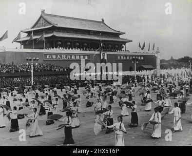 I due volti della Cina comunista: La sfilata dei fan ballerini - il 1st, 1954, il quinto anniversario dell'istituzione della Cina comunista, una parata di mammut si tenne in piazza Tien An Men a Pechino, dove Mao TSE-tung prese il saluto. L'esposizione era composta da illustrazioni di pace e guerra. La nostra fotografia mostra gli artisti cinesi che eseguono una danza del ventilatore di fronte al banco di revisione. Notare il grande ritratto di Mao TSE-tung sulla parete. Ottobre 21, 1954. (Foto con fotocamera premere). Foto Stock