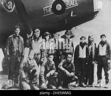 Equipaggio di Stati Uniti Bomber dopo RAID sulla Germania -- Un equipaggio di bombardamento dell'esercito degli Stati Uniti pone per una foto sotto il naso di 'l'Eightball', la loro Fortezza volante, prima di entrare nella loro ricreazione shack da qualche parte in Inghilterra per il caffè caldo e una sigaretta. L'aereo fu uno dei tanti che razziò Wilhelmshaven ed Emden nel primo raid americano di luce del giorno sul territorio tedesco. Marzo 22, 1943. (Foto di Interphoto News Pictures, Inc.). Foto Stock