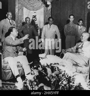 Brindisi per il Goneralissimo--Presidente Elpidio Quirino (a sinistra, seduto), presidente delle Filippine, offre un brindisi dalle Filippine al Generalissimo Chiang Kai-Shek della Cina (seduto, a destra) al suo arrivo a Baguio, capitale estiva delle isole. Chiang è venuto nelle Filippine per le conferenze su una formazione proposta di un'Unione pacifica dei paesi. Contrario al comunismo. Guardando sullo sfondo ci sono assistenti militari e interprete. Luglio 13, 1949. (Foto di AP Wirepoto) ;Toast per i Goneral Foto Stock