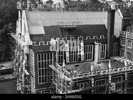 Riparazioni dei danni di guerra al Tempio -- Sala del Tempio Centrale dal sud-ovest. Il tetto, la cui parte superiore è stata bruciata durante la guerra, è stato temporaneamente coperto con lenzuola di amianto ondulato. L'edificio inferiore in primo piano contiene le Camere del Parlamento e la Camera della Regina (le due finestre in basso a destra). Gli operai stanno spingendo avanti con il restauro famoso Middle Temple Hall a Londra in modo che sarà pronto nel mese di luglio, quando i Maestri di Panchina del Medio e del Tempio interno entreranno Foto Stock