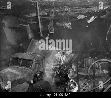 Scena di Holland Tunnel Blast. Questa è stata la scena nel tunnel olandese appena ad ovest della linea mediana, maggio 13, dopo che i tamburi di sostanze chimiche su un camion (a sinistra) esplose, riempiendo la strada subacquea di fumi di disolfuro di carbonio, Diversi camion catturarono il fuoco dall'esplosione che strappò le sezioni della parete e del soffitto del tunnel. La metropolitana collega Jersey City, N.J., con New York City. Maggio 13, 1949. (Foto di stampa associata). ;Scena di Holland Tunnel Blast. Questa era la scena in Olanda Tun Foto Stock