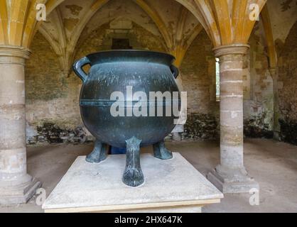 Il Mechlin Pot o Black Cauldron, un grande cavoldron risalente al 1500 nella stanza di riscaldamento, Lacock Abbey, Lacock, Wiltshire Foto Stock