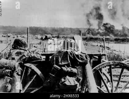 Tedesco Shell Enemy River Bank - sul fronte russo-tedesco -- colonne di fumo (sullo sfondo) marcare incendi iniziati da conchiglie di artiglieria tedesca delle truppe d'élite SS. Due fanti tedeschi (primo piano) e fucile fuoco a quello di grandi pistole, sul fronte orientale, secondo la didascalia tedesca. Giugno 12, 1941. (Foto di ACME). Foto Stock