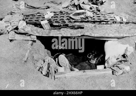 I Marines degli Stati Uniti dormono nel foxhole ornato di Iwo Jima -- i Marines degli Stati Uniti riposano in una foxhole scavata nella sabbia di Iwo Jima, bastione dell'Isola del Vulcano 750 miglia (1.200 km) da Tokyo, capitale del Giappone. Il tetto della foxhole ha un rinforzo in metallo di rivestimento airstrip per la protezione contro lo shrapnel nemico. I Marines sbarcarono su Iwo, che era sotto l'amministrazione della metropoli di Tokyo, il 18 febbraio 1945, e portarono fine alla resistenza giapponese organizzata il 15 marzo, dopo una battaglia amara e sanguinosa. Di ma Foto Stock