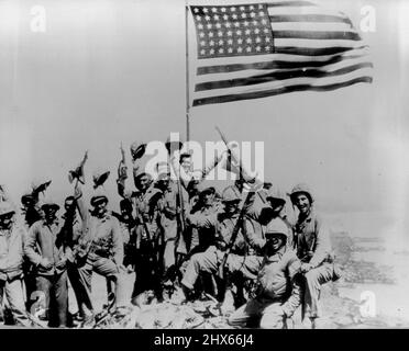 Hanno messo la bandiera degli Stati Uniti in cima a Suribachi - Marines del Regiment 28th, divisione 5th, onda di fronte alla bandiera americana hanno messo in cima a Suribachi, il vulcano di Iwo Jima, dopo un'amara battaglia in salita con i giapponesi in grotte e saccheggi sul forte naturale di Iwo Jima. Febbraio 27, 1945. (Foto di Joe Rosenthal, AP). Foto Stock