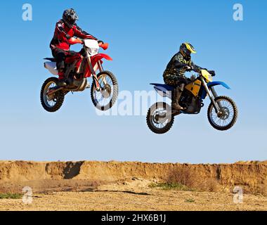 Saltare all'unisono. Azione di due biker a mezz'aria. Foto Stock