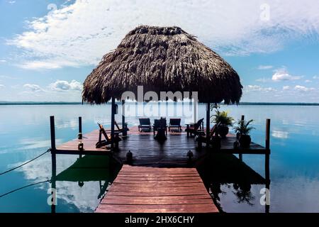 Molo e capanna Palapa sul bellissimo lago Peten Itza, El Remate, Petén, Guatemala Foto Stock