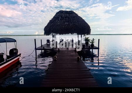 Molo e capanna Palapa sul bellissimo lago Peten Itza, El Remate, Petén, Guatemala Foto Stock