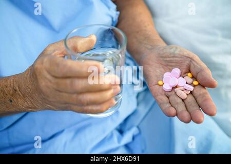 Asian anziano anziano donna anziana che tiene la vitamina C pillole farmaco in mano, sano forte concetto medico. Foto Stock