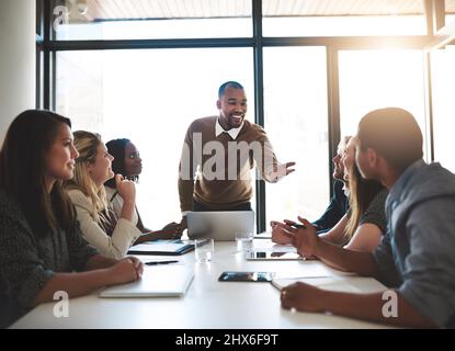 Mer amore per sentire ciò che si pensa. Scatto di un giovane uomo d'affari che guida il suo team in una riunione in ufficio. Foto Stock