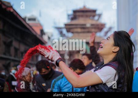 Bhaktapur, Bagmati, Nepal. 10th Mar 2022. Una donna lancia la polvere di vermilion dopo aver eretto il chir, un palo di legno, per segnare l'inizio del festival Holi, a Basantapur, Kathmandu. (Credit Image: © Amit Machamasi/ZUMA Press Wire) Foto Stock