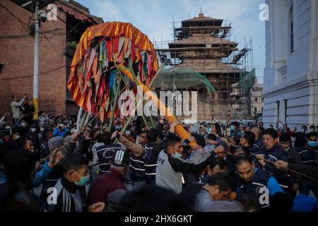 Bhaktapur, Bagmati, Nepal. 10th Mar 2022. I membri di Manandhar Guthi erecting Cerimonial Bamboo Log noto come Chir insieme con le strisce vibranti di stoffa, che rappresentano il fascino della buona fortuna, il primo giorno di Holi Celebration, i festival dei colori a Basantapur Durbar Square, Kathmandu, Nepal. (Credit Image: © Amit Machamasi/ZUMA Press Wire) Foto Stock