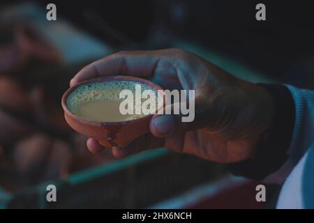un uomo che tiene una tazza di tè di argilla. Foto Stock