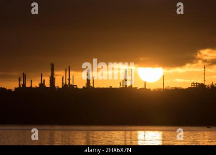 WhiteGate, Cork, Irlanda. 10th Marzo, 2022.Sunrise crea una silhouette delle torri di distillazione presso la raffineria di petrolio a WhiteGate, Co. Cork, Irlanda. - Credit; David Creedon / Alamy Live News Foto Stock