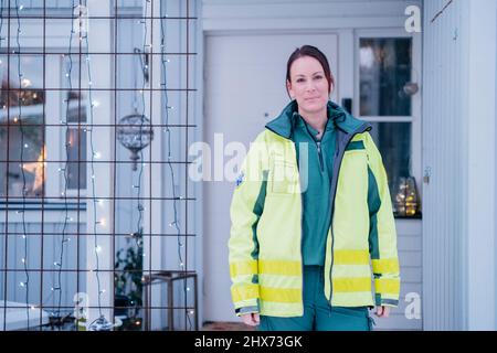 Personale dell'ambulanza di fronte alla casa del paziente Foto Stock