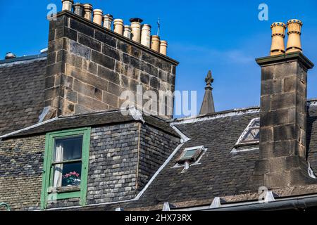 Tetti, Chimney Pot e dettaglio finestra contro un cielo blu. Casa tra Candlemaker Row e Greyfriars Graveyard, Edimburgo. Foto Stock