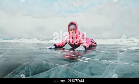 Ragazza che cammina su ghiaccio rotto del lago ghiacciato Baikal. Il viaggiatore della donna esplora e guarda un galleggiamento di ghiaccio. Luogo magico più puro nella natura. Ice soluzioni di viaggio Foto Stock