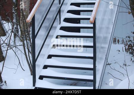 in inverno, i gradini delle scale sono coperti di neve bianca e pura Foto Stock
