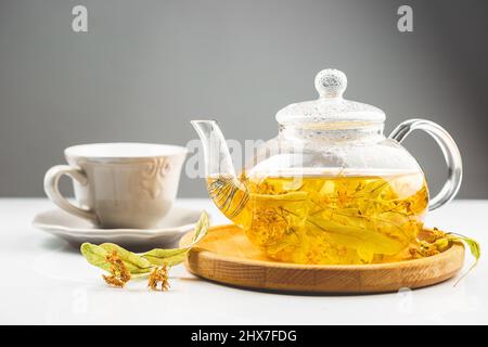 Tè di fiori di Linden o tilia nella pentola trasparente. Linden è una pianta alternativa della medicina usata nell'erborismo Foto Stock