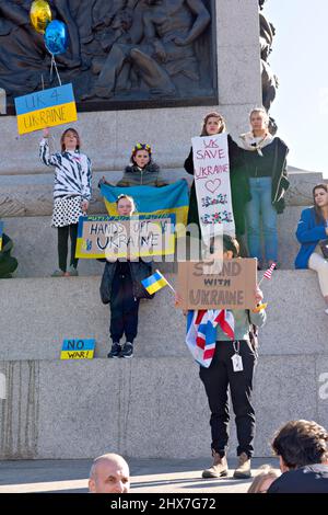 Un gruppo di giovani tiene in mano le bandiere di una protesta di Londra contro l'invasione russa dell'Ucraina il 27 febbraio 2022 Foto Stock