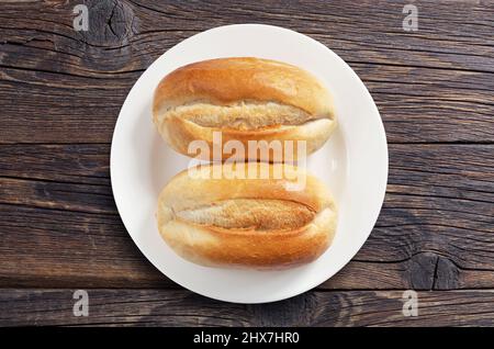 Pani di pane bianco in piatto su vecchio tavolo di legno, vista dall'alto Foto Stock