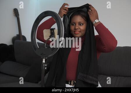 Giovane donna arabica insegnamento come risolvere il hijab online. Foto Stock
