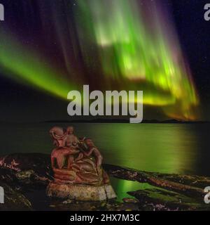 Aurora boreale sulla Madre del mare, Sassuma Arnaa - una figura leggendaria nella cultura inuit. Sculpure di Christian Rosing nel porto coloniale Foto Stock