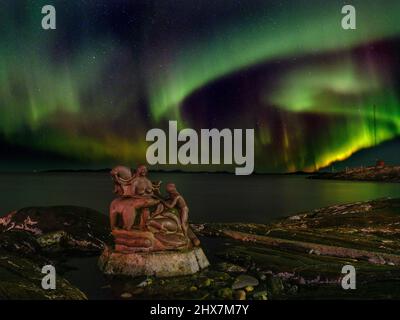 Aurora boreale sulla Madre del mare, Sassuma Arnaa - una figura leggendaria nella cultura inuit. Sculpure di Christian Rosing nel porto coloniale Foto Stock