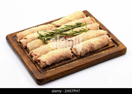 Schnitzel di manzo isolato su sfondo bianco. Delizioso schnitzel di carne cruda preparato con pangrattato e sesamo bianco Foto Stock