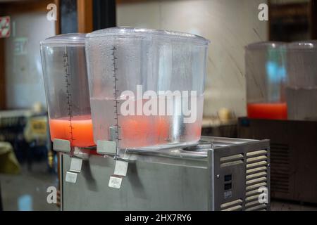 leva ravvicinata del dispenser per succo d'arancia fresco. Foto Stock