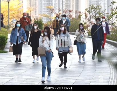 (220310) -- HONG KONG, 10 marzo 2022 (Xinhua) -- le persone che indossano maschere facciali camminano a Tsuen WAN, Hong Kong della Cina meridionale, 10 marzo 2022. La Regione amministrativa speciale di Hong Kong (HKSAR) ha segnalato 24.390 nuovi casi COVID-19 il 9 marzo. (Xinhua/lo Ping Fai) Foto Stock