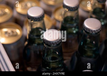 Tappi a corona su bottiglie di vetro per bevande presso un negozio di alimentari o un supermercato. Foto Stock