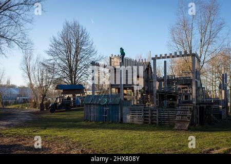 Un ragazzo si arrampica su una grande struttura costruita da vecchi pallet a Fort Plankensteijn nel parco giochi Jeugdland ad Amsterdam, Paesi Bassi. Foto Stock