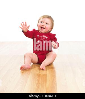 Il bambino sorridente raggiunge con la mano Foto Stock