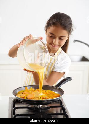 Tortilla di patate dolci - aggiunta del composto di uova alla padella di patate dolci e peperoni (passaggio 3 del 4) Foto Stock