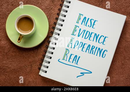 FEAR acronym - false prove che appaiono reali, scrittura a mano in un libro di schizzo con una tazza di caffè, concetto di business Foto Stock