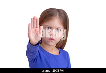 Bambino che mostra mano come segno per fermare il fuoco sulla palma, isolato su sfondo bianco guardando la cinepresa vita su caucasica bambina di 5 anni in blu Foto Stock