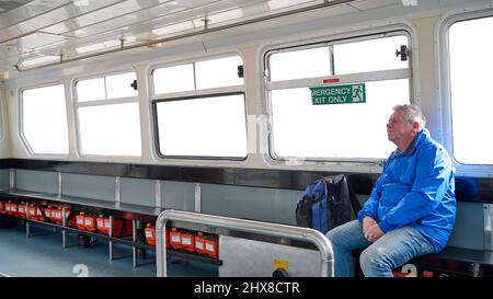 Passeggero solitario a bordo del traghetto per estuario del Wyre che viaggia verso l'estremità di Knott da Fleetwood Foto Stock