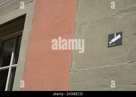 Simbolo di videosorveglianza sulla parete di un edificio. Schermo metallico con pittogramma di una telecamera tvcc posta all'esterno di un edificio. Foto Stock