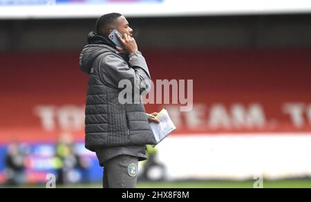 Assistente manager di Crawley Lewis Young al telefono durante la Sky Bet League due partite tra Crawley Town e Scunthorpe unite al People's Pension Stadium , Crawley , Regno Unito - 5th Marzo 2022 - solo per uso editoriale. Nessun merchandising. Per le immagini Football si applicano restrizioni fa e Premier League inc. Nessun utilizzo di Internet/cellulare senza licenza FAPL - per i dettagli contattare Football Dataco Foto Stock