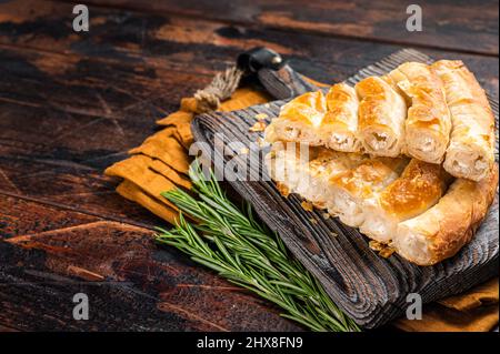 Torta di spanakopita greca fatta in casa con formaggio biologico su tavola di legno. Sfondo in legno. Vista dall'alto. Spazio di copia Foto Stock