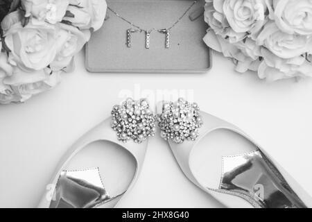 Accessori per matrimoni su sfondo bianco pulito. Scarpe, fiori e gioielli Foto Stock